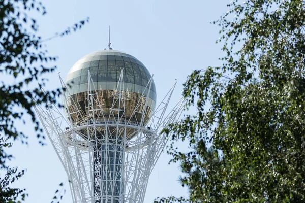 Astana, agosto 2017. Specchio palla Baiterek attraverso il fogliame verde degli alberi . — Foto Stock