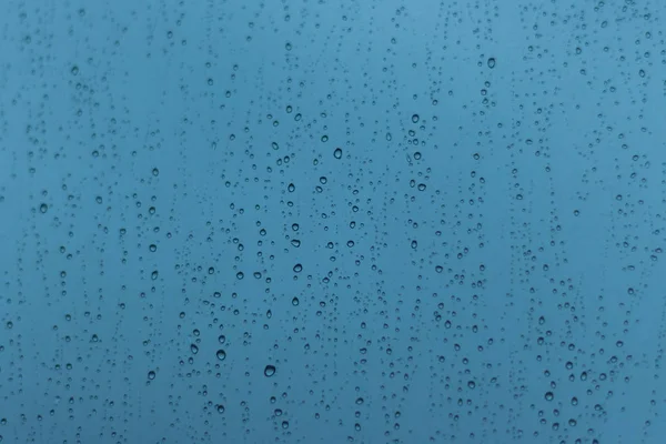 Gouttes d'eau de pluie de différentes tailles sur la fenêtre . — Photo