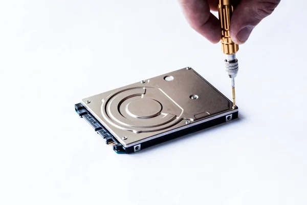 Repair of hard disk for laptop. The computer master wipes the screw with a screwdriver. — Stock Photo, Image
