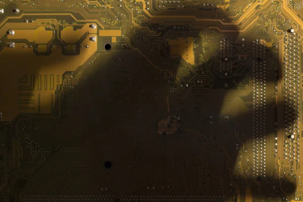 Schatten von Hand auf dem gelben Computermotherboard. — Stockfoto