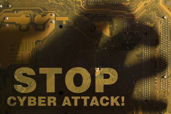 Napis "Stop cyber ataku" przez cień ręki na żółte płyty głównej. — Zdjęcie stockowe
