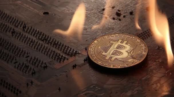 Zlatý Bitcoin spaluje s ohněm na kolejích elektronické desky. — Stock video