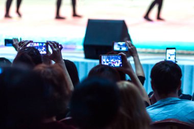 Bazı seyirciler salonda ateş dans performansı üstünde onların telefon. Sahne Alanı'nda sanatçıların konser programı. Bulanık.