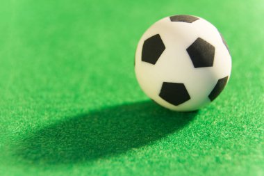 Hediyelik eşya futbol topu yeşil bir arka plan üzerinde. Futbol bir sembolü. Makro. Süper yakın çekim.