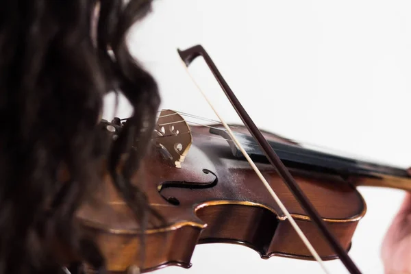 Chica tocando el violín. Primer plano. Vista desde el lado del hombro a través del cabello. El arco toca las cuerdas. Tema musical. Fondo blanco . — Foto de Stock
