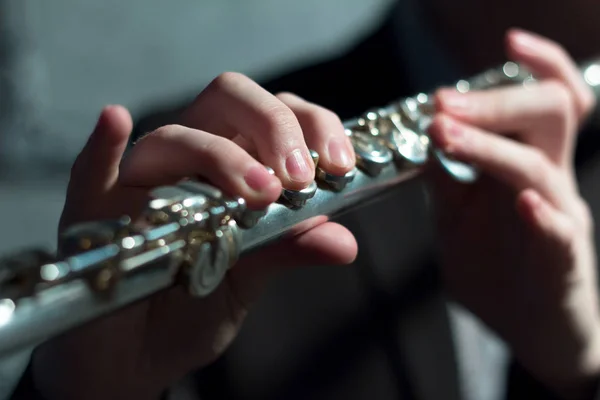 Männerhände an einem Blasinstrument. Flöte spielen. geringe Schärfentiefe. Musik und Klang. Licht modellieren. — Stockfoto