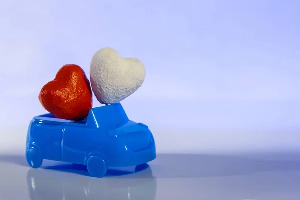 Közelről. Vörös és fehér szív a kék kabrió autó a világos háttér. Fogalma a szeretet és a kocsi. Valentin-napot az autósoknak. Nászút utazás saját eszközökkel. Esküvői két szív. Copyspace. — Stock Fotó
