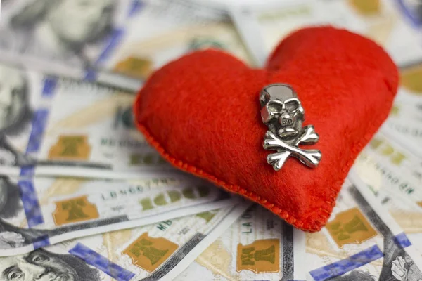 Small DOF. Dollars, heart, death. Concept Piracy and feelings, Wedding contract, dangerous love for money, terrible Valentine\'s Day. Close-up.