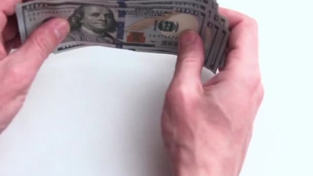 Primo piano. Mani maschili alzare e impilare ordinatamente una pila di dollari USA. Mille dollari su sfondo bianco. Ricchezza e finanze. Guadagni e corruzione . — Video Stock