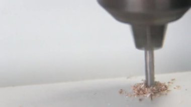 Bir elektrikli matkap kullanarak beyaz bir Sunta delik delme. Makro. Portre. DIY ev. Ahşap mobilya.