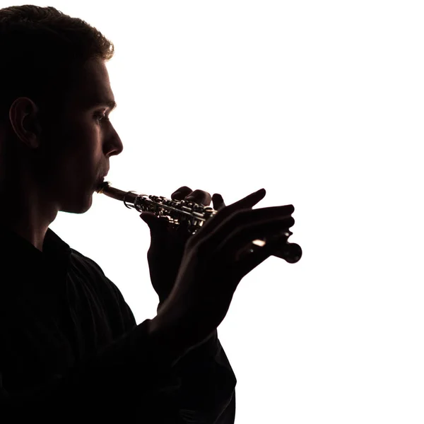 Un primer plano de la silueta de una flauta en las manos y en los labios de un músico. El tipo da sonidos a un fondo blanco. Una foto cuadrada. Copiar espacio . — Foto de Stock