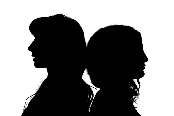Silhouette. Two girls stand with their backs to each other on a white background. — Stock Photo, Image
