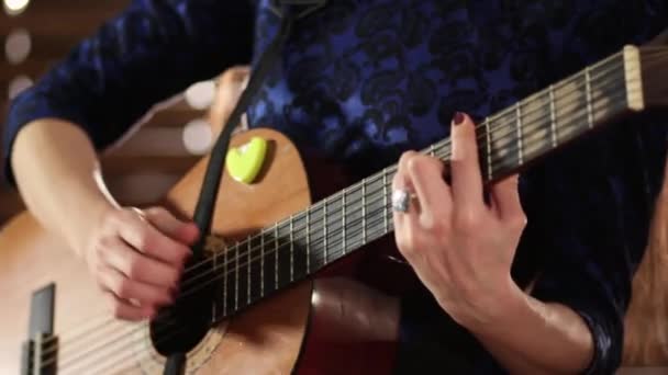 手上的弦吉他 焦点锐度从一只手移动到另一个 穿蓝色连衣裙的女孩正在演奏乐器 — 图库视频影像