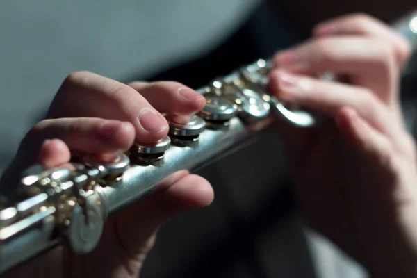 Chicos manos en un instrumento musical de viento. Tocando la flauta. Profundidad de campo superficial. Música y sonido. Modelado de luz . — Foto de Stock