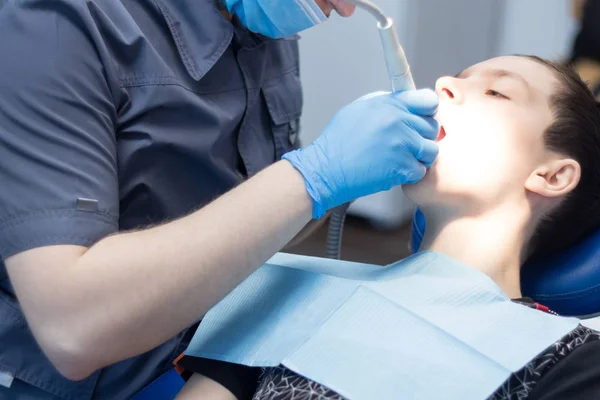 Een jonge man in de tandheelkunde bij een receptie met een tandarts. Tandheelkundige behandeling. — Stockfoto