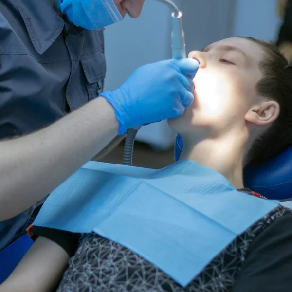 Een tiener in de tandheelkunde bij de benoeming van een tandartsen. Tandheelkundige behandeling. Een vierkante afbeelding. — Stockfoto