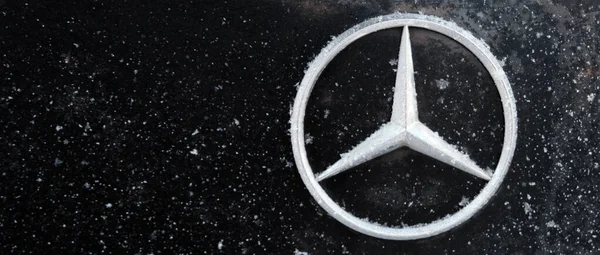 Kazachstan, Kostanay, 2019-01-19. Mercedes ikoniczny logotyp pokryty płatkami śniegu. Zimą. Zbliżenie. Bagażnik czarnego samochodu. Odbiór. Mercedes-Benz jest producentem niemieckiej firmy Daimler Ag. Zdjęcia Stockowe bez tantiem