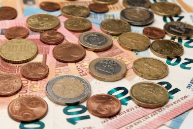 Bozuk paralar Euro banknotlarının üzerinde. Finansal geçmiş. Avrupa parası. Zenginlik, yoksulluk, kriz, birikim veya başarı kavramı.