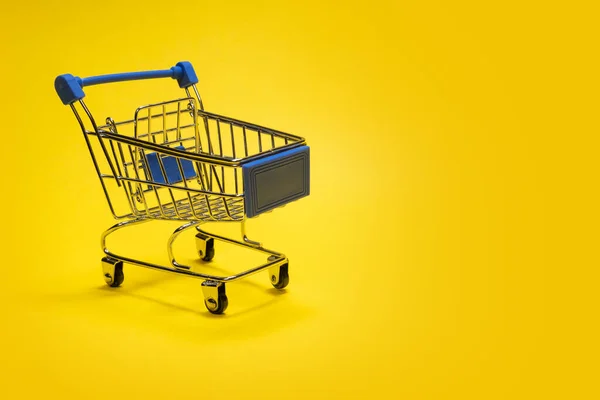 Подарункова коляска для покупок. Жовтий фон. Копіювати простір. Шаблон для рекламних покупок онлайн або офлайн. Концепція знижок і продажів, бізнес і кошик покупця або продавця . — стокове фото