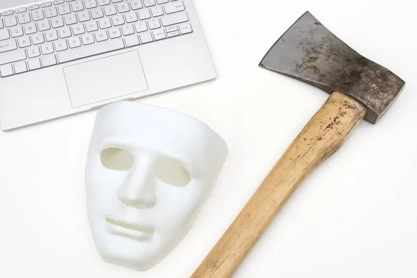 Maske, Computer und Axt auf weißem Hintergrund. Konflikt kriminellen Konzept der Cyber-Angriff oder Verteidigung gegen Hacker. Nahaufnahme. — Stockfoto