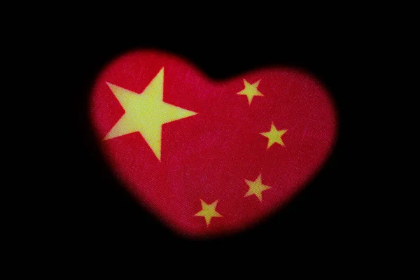 Symbol lásky a čínského vlastenectví. Tvar srdce na červené vlajce se žlutými hvězdami. Černé pozadí. Koncept svatby v Číně nebo oslavy Valentýna. — Stock fotografie