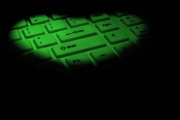 Coeur vert fait de lumière vive sur un clavier d'ordinateur. Le concept de félicitations pour la Saint-Valentin, l'amour numérique, sortir ensemble et flirter sur Internet. Fond noir. Espace de copie . — Photo