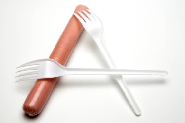 Sosis ve iki çatal A harfi gibi katlanmış. Beyaz arka plan. Fast food, açlık veya yiyecek eksikliği kavramı, alfabe, tek kişilik ucuz Gmo ürünleri.