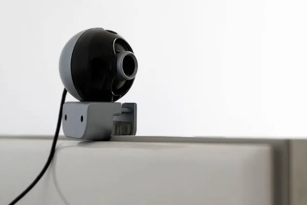 A web camera is installed on the computer monitor. Equipment for video recording and surveillance. The concept of remote monitoring, protection or viewing privacy, big brother. Copy space. Close-up.