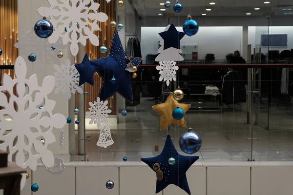Abstract festive Christmas decoration in a supermarket, clothing store, shopping center. New Year's toys, balls, stars and snowflakes hang. Background for the design of seasonal discounts and sales. — Stockfoto