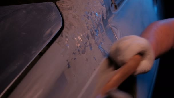 Workshop worker polishes the surface of a vehicle part. Blue tone. Classic work in a car service. Closeup of male hands in gloves with a tool. the concept of low-paid wage labor. Disaster recovery. — Stock Video