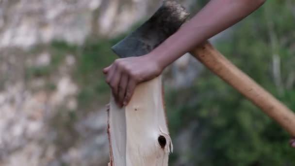 Ο τύπος μαθαίνει να κόβει ξύλα και χάνει το τσεκούρι μετά το κούτσουρο. Κοντινό πλάνο. Οικολογικός τουρισμός και ψυχαγωγία έννοια στα βουνά και τα δάση. Ταξιδιώτες κατασκήνωσης. — Αρχείο Βίντεο