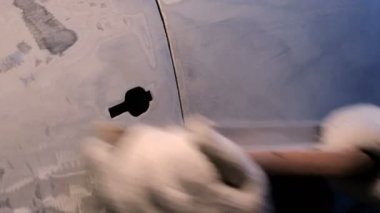 Erkek eli eldivenli, öğütücü aletle yakın plan. Kazadan sonra arabanın kapısını parçalamak. Metal bir yüzey hazırlama ve boyama için.