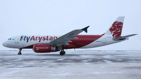 2019-12-18 Kostanay, Kazachstán. Letadlo Airbus A320 je zaparkované na zimním letišti. První let kazašské letecké společnosti Flyarystan z Nur Sultánu do Kostanaye. Royalty Free Stock Fotografie