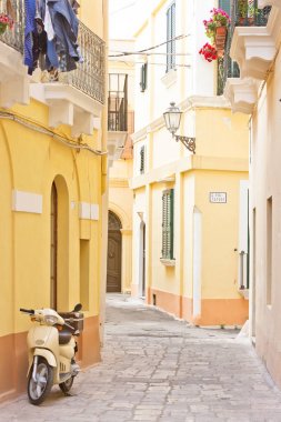 Gallipoli, Apulia - A motor scooter in a historical alleyway clipart
