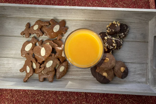 Группа различных видов вкусные сладкие рождественские печенья на светло-серой древесины со свежим апельсиновым соком — стоковое фото