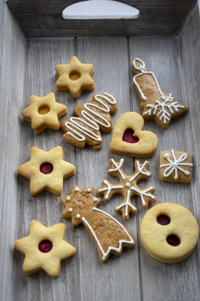 Рождественские льняные конфеты и пряничные конфеты различных форм на сером деревянном подносе — стоковое фото