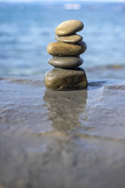 Vijf stenen cairn toren, rots zen sculptuur, bruin beige steentjes en zee licht blauwe achtergrond — Stockfoto