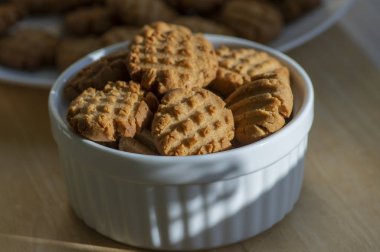 Bambu ahşap tahtanın üzerinde çok lezzetli fıstık ezmeli bisküviler. Güneş ışığı, beyaz fırında pişirilmiş sağlıklı kurabiyeler, lezzetli bir tat.