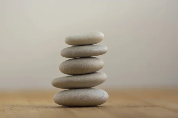 Stenen cairn op houten ondergrond, vijf stenen toren, eenvoudige poise stenen, eenvoud harmonie en evenwicht, rots zen — Stockfoto