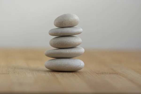 Cairn de piedra sobre fondo de madera, torre de cinco piedras, piedras simples del equilibrio, armonía y equilibrio de la simplicidad, zen de roca —  Fotos de Stock