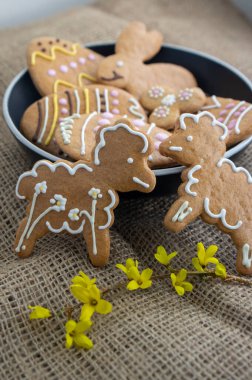 Paskalya bayramı kurabiyeleri masaya jüt masa örtüsüyle serilmiş, bir grup zencefilli kurabiye, bahar tatili süslemeleri.