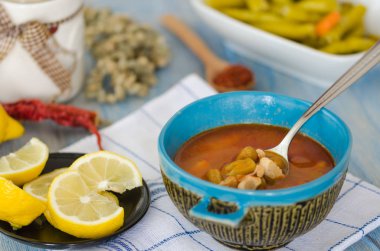 Ev yapımı bombo çorba ahşap bir masa üzerinde mavi bir kase.