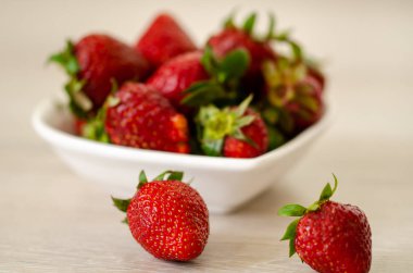 Tahta masadaki kasede taze çilekler. 