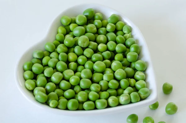 Ervilhas verdes frescas Macro - comida orgânica no prato branco . — Fotografia de Stock