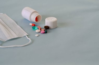 Çok renkli haplar, ağrı kesiciler, mavi arka planda ilaçlar. Mesaj için yer var..