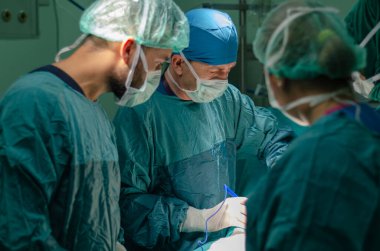 Hastanedeki histerektomi ameliyatı sırasında bir hastada konsantre doktor, asistan ve hemşire. Operasyonda elektrokoterapi kullanıyor..