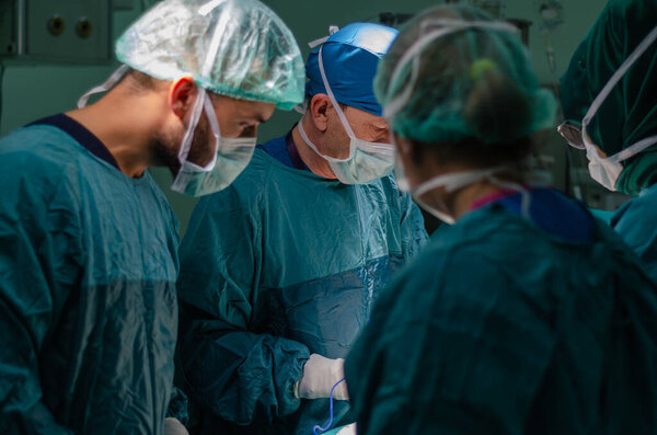 Concentrated doctor, assistant and nurse in a patient during a hysterectomy operation in a hospital. He is using  electrocautery in operation.