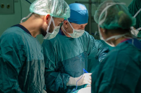 Hastanedeki histerektomi ameliyatı sırasında bir hastada konsantre doktor, asistan ve hemşire. Operasyonda elektrokoterapi kullanıyor..