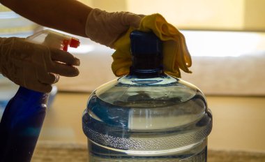 Kadın, arabacıyı koronavirüsten korumak için mutfakta dezenfekte eder..