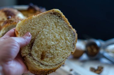 Kadın elinde lezzetli bir dilim ekmek tutuyor, yakın çekim.